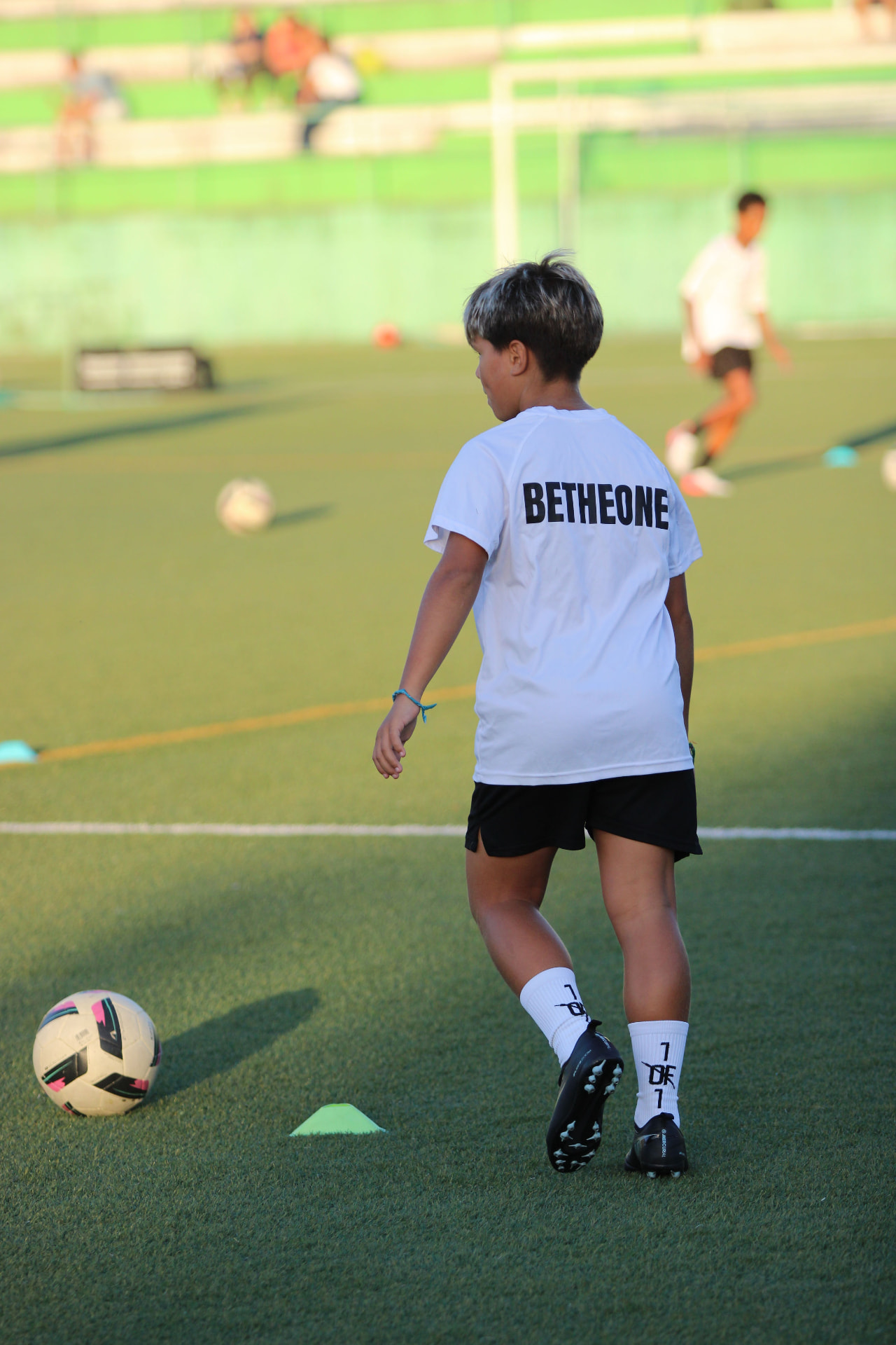 Jovem atleta da BeTheOne Academy de costas, com BETHEONE na camisola